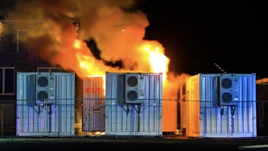 A large fireball and smoke plume from a burning battery storage building.